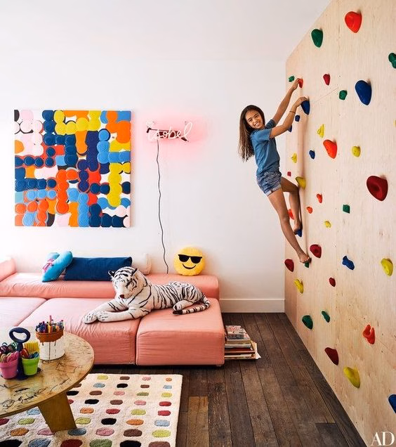 Ten-year-old Willow Romanek climbs a rock wall in the playroom