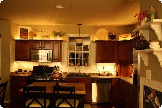 Cookware or glassware on display above kitchen cabinets 