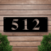Black house number on wooden wall
